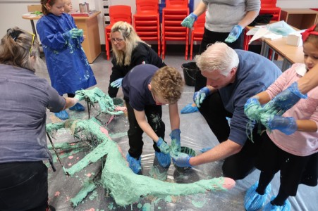 Children apply plaster to an armature at Newhall Academy
