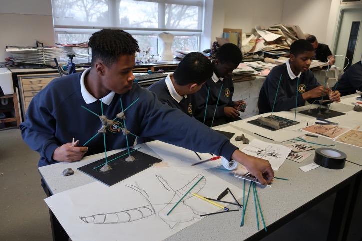 Students begin to build their sculptures using wooden sticks and clay